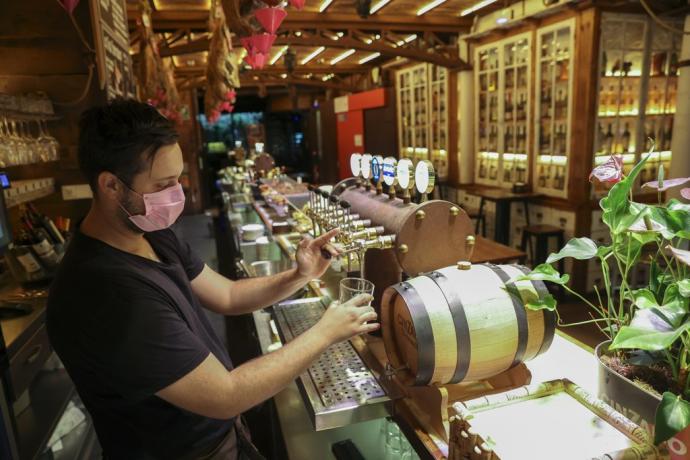 Un camarero sirviendo una cerveza en un bar de Pamplona.