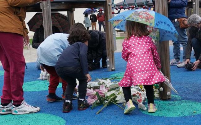 Varios niños depositan flores en una concentración en el parque donde fue secuestrado un niño de 9 años.