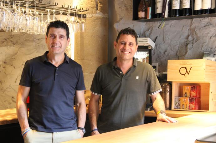 Los hermanos Jorge y Raúl Ripa posan en una barrica con taburetes situada como mesa de terraza en la fachada del bar de vinos 'Parranda'.