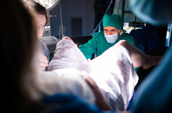 Un equipo médico atiende a una mujer durante el parto.