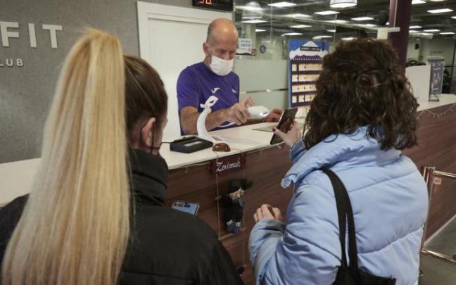 Una joven muestra su pasaporte covid para acceder a un gimnasio. Una joven muestra su pasaporte covid para acceder a un gimnasio.