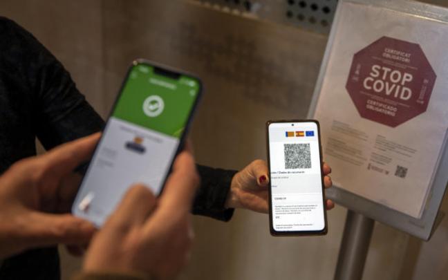 Una persona muestra su pasaporte covid. Una persona muestra su pasaporte covid.