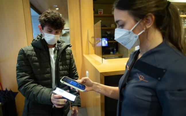 Clientes enseñan el pasaporte covid para entrar a un restaurante en Navarra.