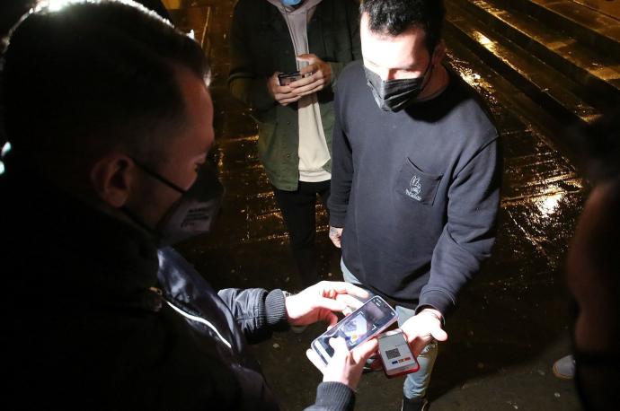 Jóvenes muestran el pasaporte covid para acceder a un local de ocio nocturno.