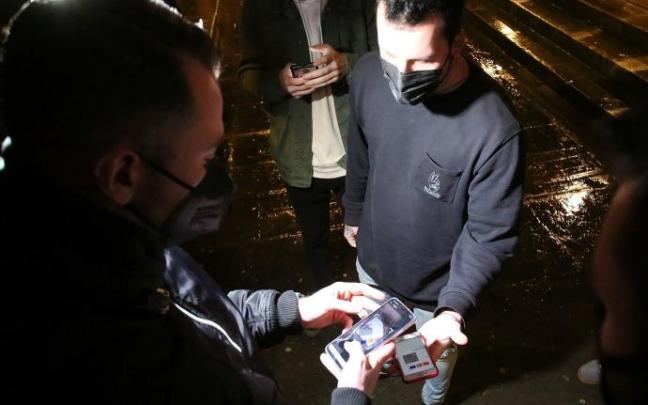 Jóvenes muestran el pasaporte covid para acceder a un local de ocio nocturno.
