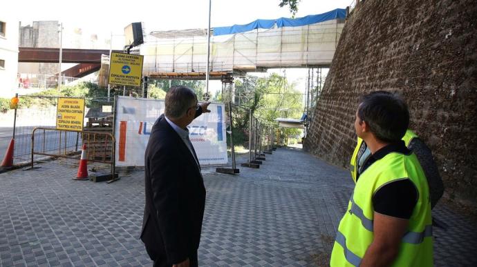 El alcalde Maya conversa con un técnico frente las obras de reparación en la pasarela del Labrit.