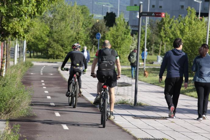 Varias personas pasean o circulan en bicicleta por Vitoria.