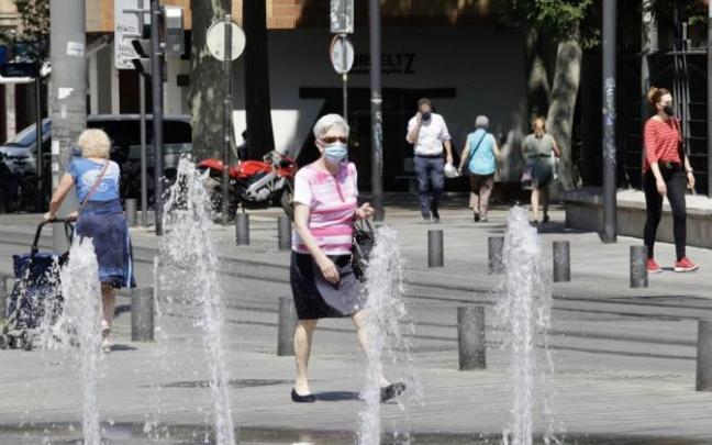 Varias personas pasean por Vitoria.