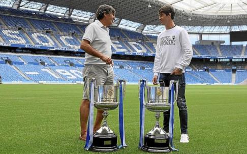 Agustín Gajate y Aritz Elustondo dialogan amistosamente sobre el verde del Estadio de Anoeta con las dos Copas como protagonistas.