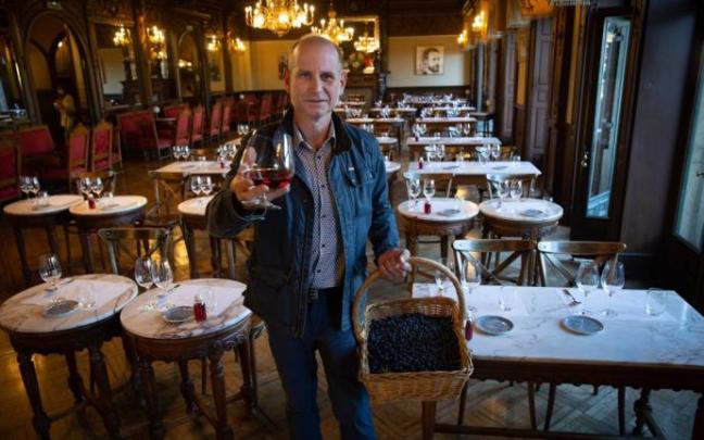 Adrián Subía posa con una copa de pacharán navarro y una cesta de endrinas en el salón del Nuevo Casino en la Plaza del Castillo.