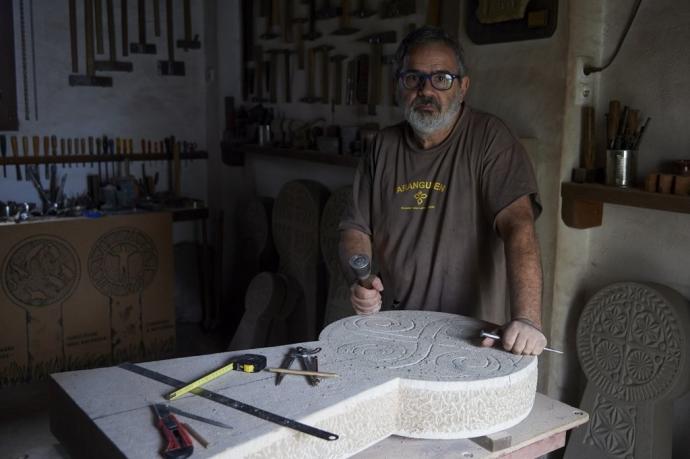 Iraizoz talla una estela con el símbolo del lauburu en el taller de su casa en la Magdalena.