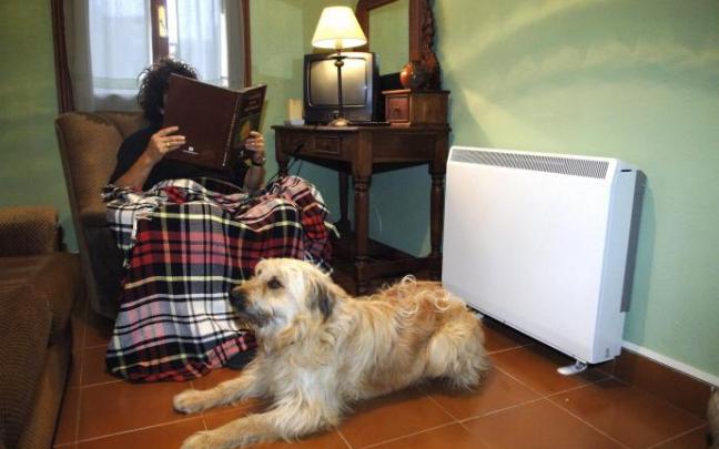 Persona leyendo con la luz encendida, al lado de la calefacción.