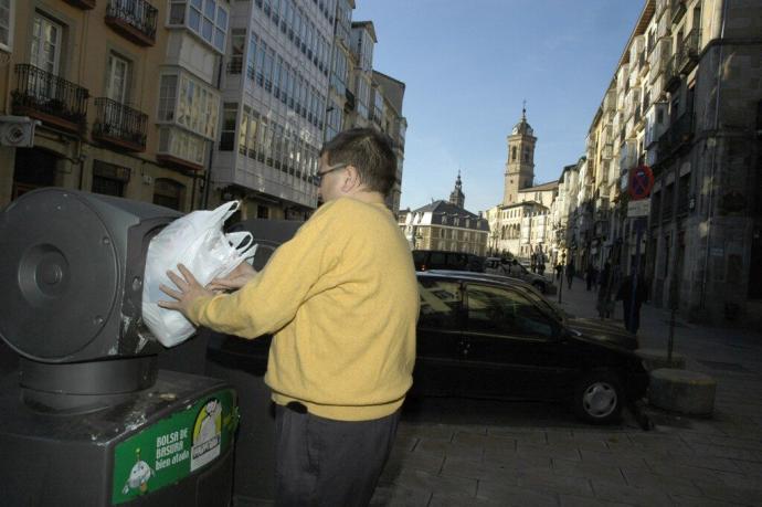 Persona depositando una bolsa de basura en el Casco Viejo de Vitoria.