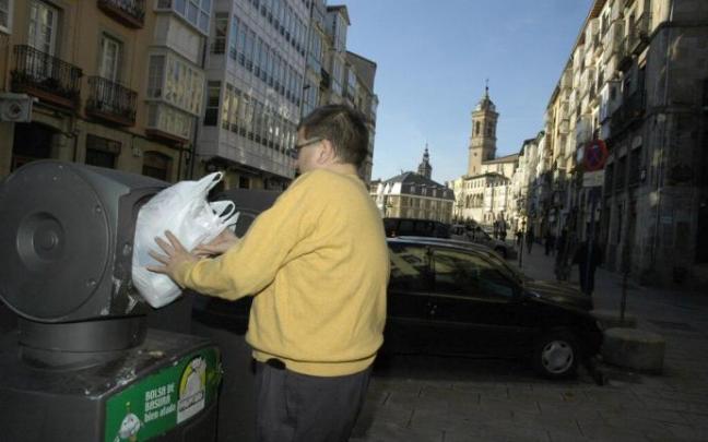 Persona depositando una bolsa de basura en el Casco Viejo de Vitoria.