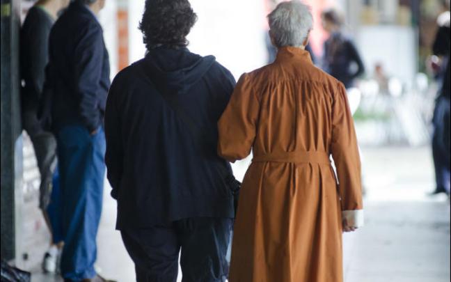 Una persona mayor pasea con su cuidadora