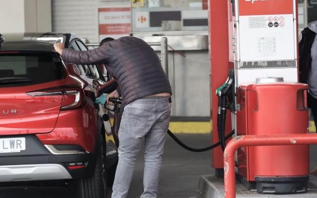 Una persona recarga combustible en una gasolinera.