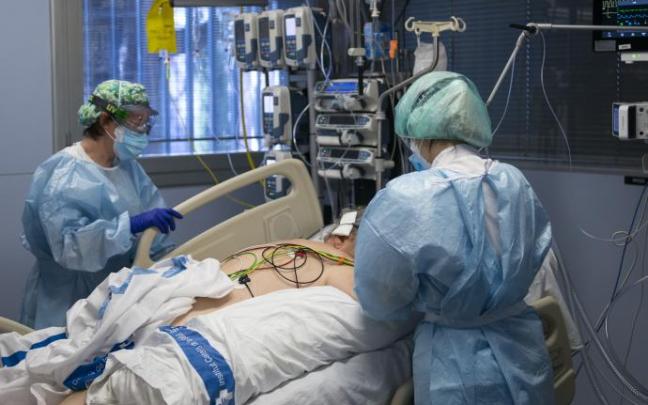 Personal sanitario atendiendo a un paciente ingresado en la Unidad de Cuidados Intensivos.
