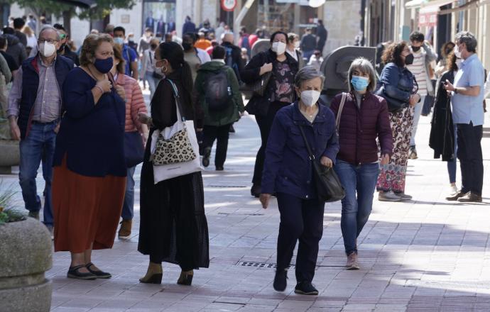 Personas andando por la calle con mascarilla.