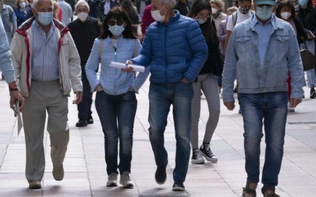 Personas andando por Vitoria con mascarilla.
