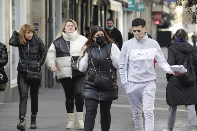 Personas con mascarilla por la calle.