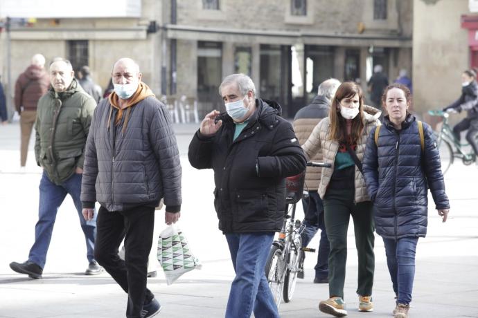 Personas con mascarilla por la calle.