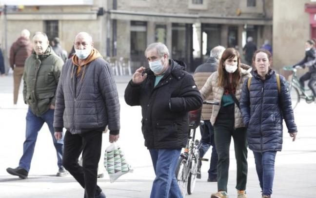 Personas con mascarilla por la calle.