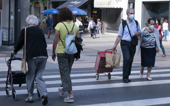 Personas paseando por Vitoria con mascarilla.