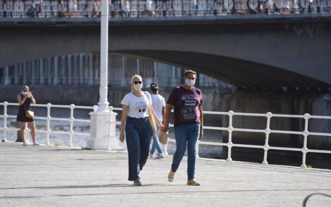 Dos personas pasean por el entorno de la ría en Bilbao