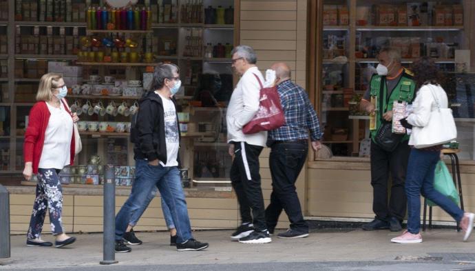 Personas paseando por las calles de Vitoria, la mayoría con mascarilla.