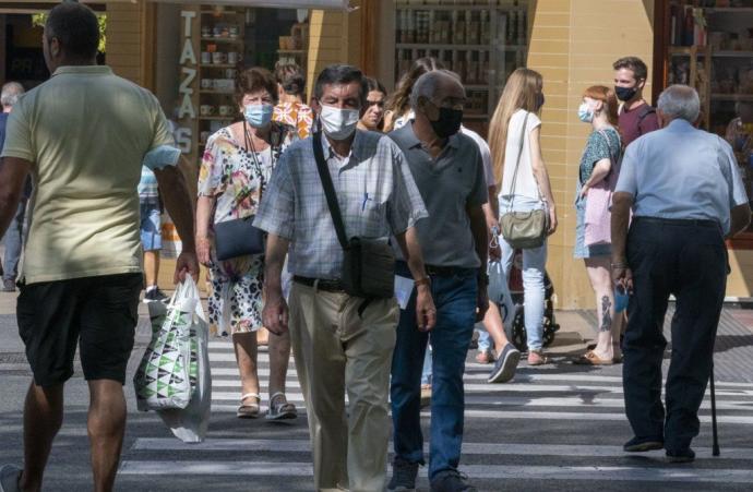 Personas paseando por las calles de Vitoria con mascarilla.