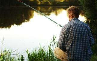 Un pescador espera paciente a que un pez entre al cebo. Un pescador espera paciente a que un pez entre al cebo.