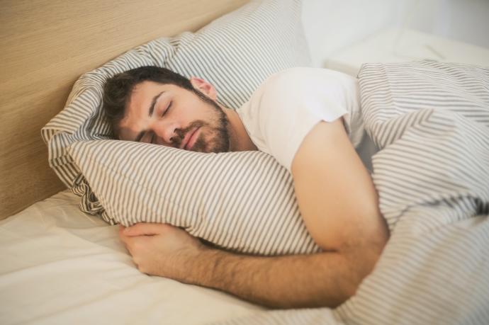 Un hombre duerme plácidamente en la cama.