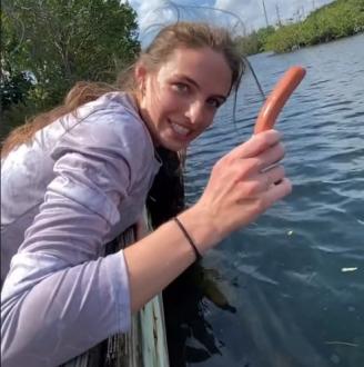 La joven, dispuesta a ofrecer una salchicha a los peces.