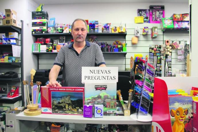 El comerciante de Estella 'Ino' posa en el mostrador de su librería con los diferentes productos especializados, aún en venta, que ha producido en los últimos dos años.