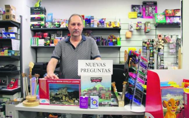 El comerciante de Estella 'Ino' posa en el mostrador de su librería con los diferentes productos especializados, aún en venta, que ha producido en los últimos dos años.