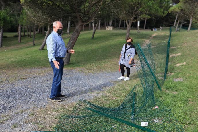 Dos vecinos observan la parte derribada de la valla que se puso el pasado verano para controlar los accesos al pinar.