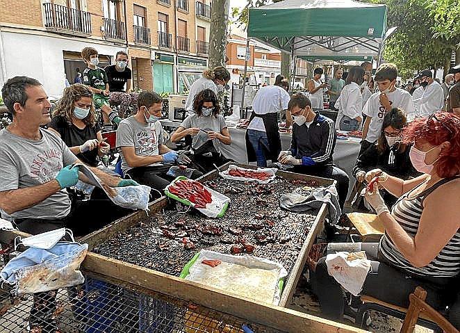 Un grupo de lodosanos pelando pimiento en directo.