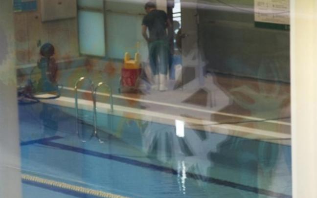 Un operario trabaja en la piscina cubierta del centro civico Aldabe.