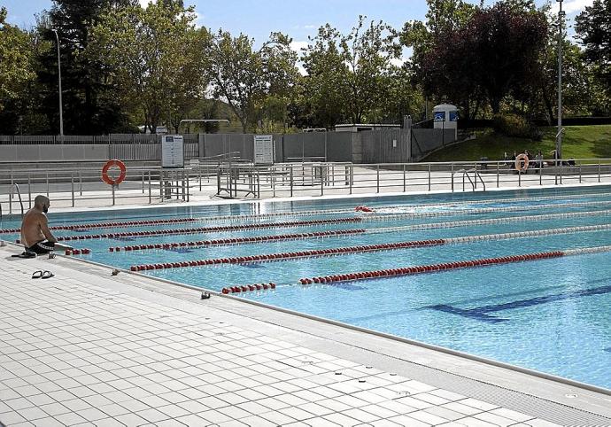 Un solitario bañista se remoja las piernas en el borde de la piscina de Mendizorrotza ayer, poco antes del mediodía. Foto: Josu Chavarri