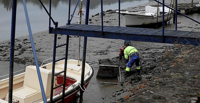 Un trabajador retirando una embarcación abandonada. Foto: N.G.