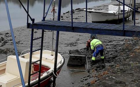 Un trabajador retirando una embarcación abandonada. Foto: N.G.