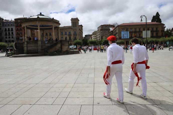 Dos personas, vestidas de blanco, en una Plaza del Castillo vacía en 2020 por la pandemia.