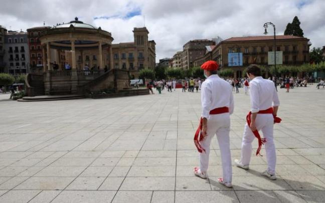 Dos personas, vestidas de blanco, en una Plaza del Castillo vacía en 2020 por la pandemia.
