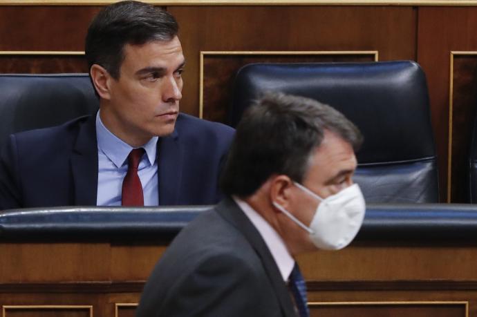 El presidente del Gobierno español, Pedro Sánchez, ve pasar al portavoz del PNV en el Congreso, Aitor Esteban