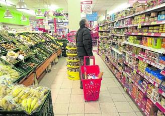 Un hombre observa la estantería repleta de alimentos de un supermercado. Foto: Josu Chavarri