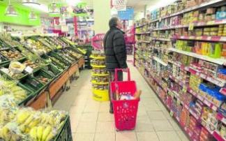 Un hombre observa la estantería repleta de alimentos de un supermercado. Foto: Josu Chavarri