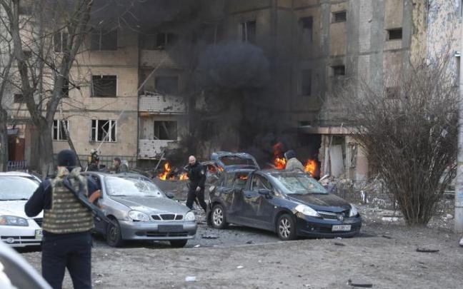 Bomberos y equipos de seguridad ucranianos trabajan en un edificio alcanzado por misiles rusos en Kiev.