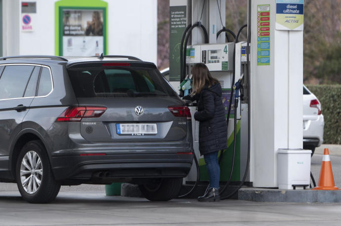Una mujer reposta combustible en una gasolinera.