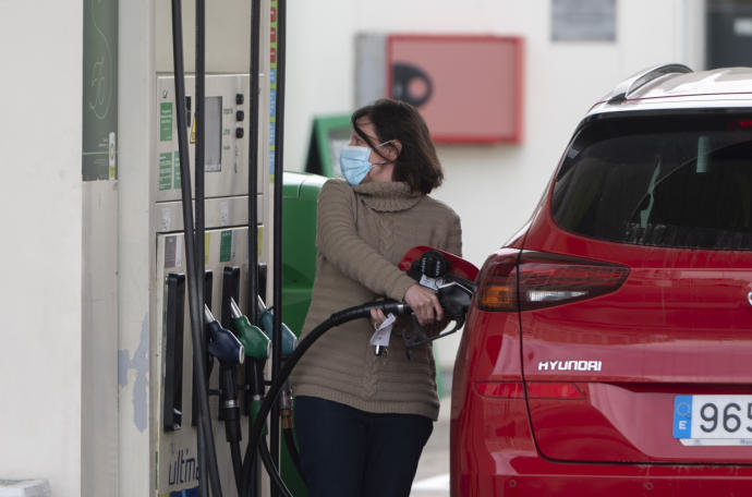 Una mujer observa el precio de la gasolina que marca un nuevo récord.