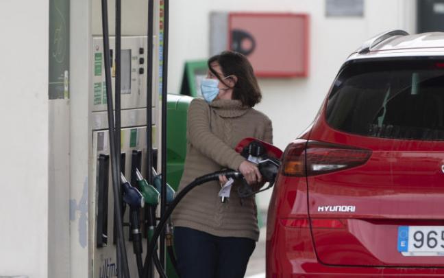Una mujer observa el precio de la gasolina que marca un nuevo récord.